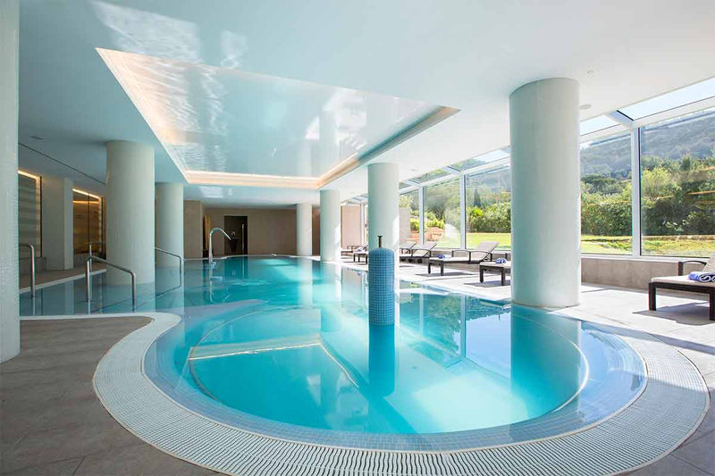 View of the indoor pool with jacuzzi and gooseneck, counter current and beds of the Mallorca Wellness SPA - Eurotel Punta Rotja