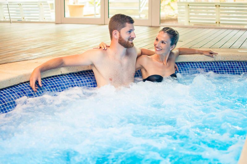 Couple sitting in jacuzzi with smiling faces