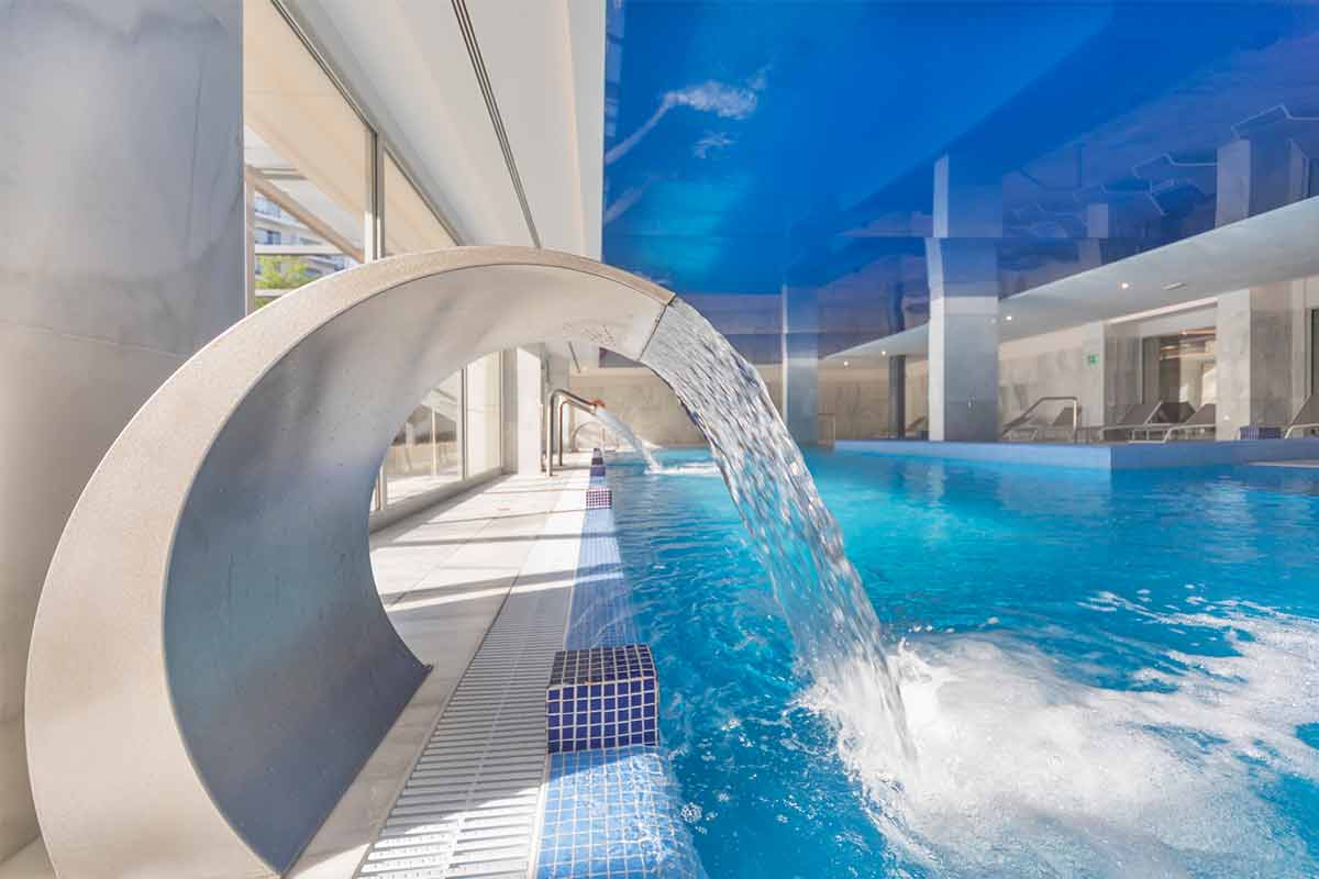 View of the indoor pool with jacuzzi and gooseneck and beds of the Mallorca Wellness SPA - Gran Playa de Palma