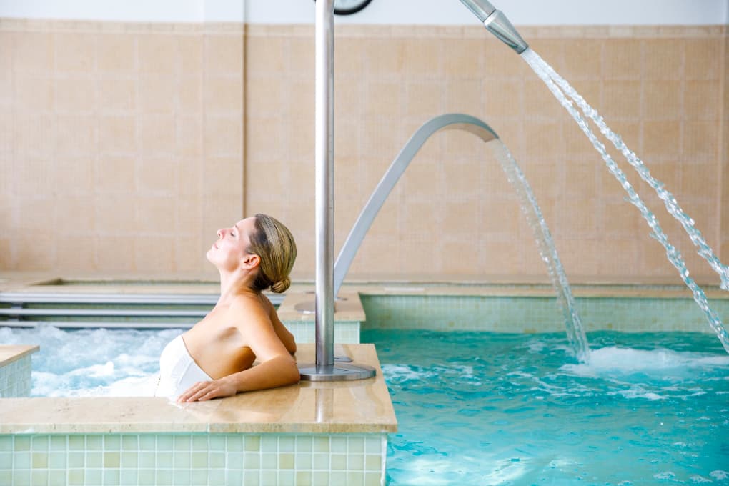 Woman relaxing in the heated pool at Spa Viva Cala Mesquida Suites in Mallorca – a moment of pure tranquility.